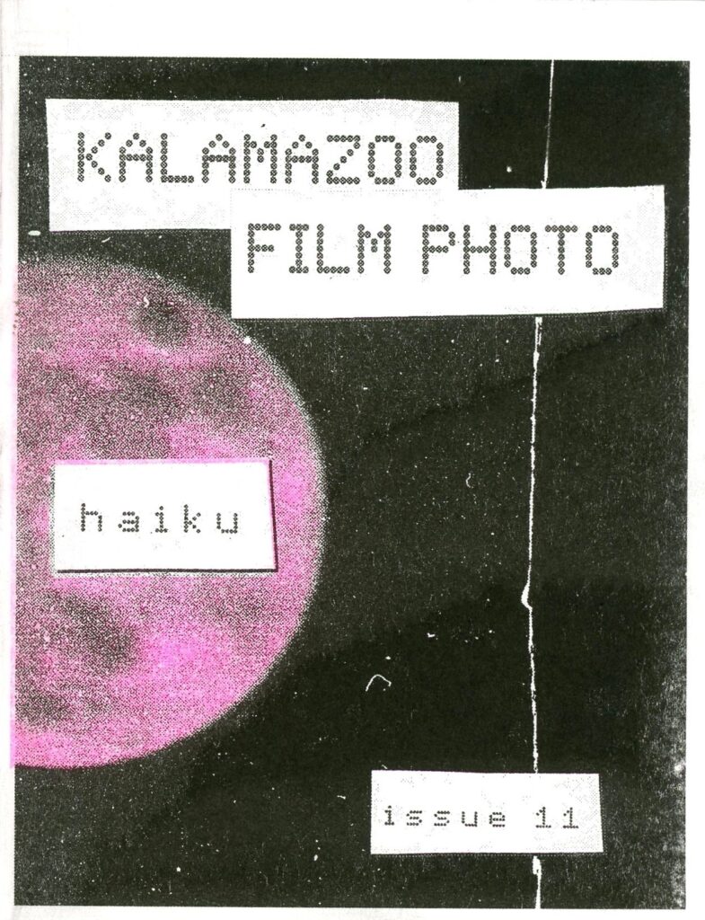 image of the front cover of kzoo film photo issue 11 zine, the cover is black with a pink moon partially visible. text reads "KALAMAZOO FILM PHOOTO, HAIKU, ISSUE 11"